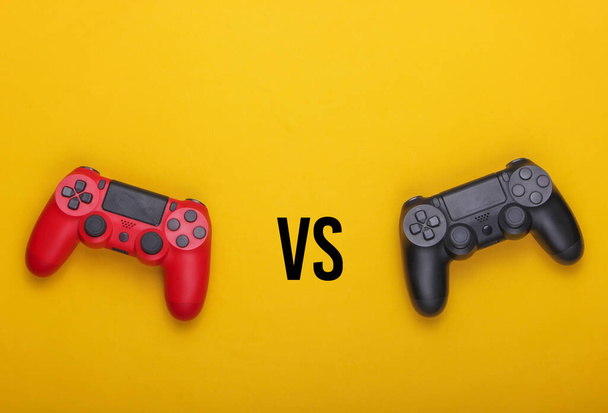 Gamer Championship, Versus. Two gamepads on a yellow background. Top view - Photo, Image