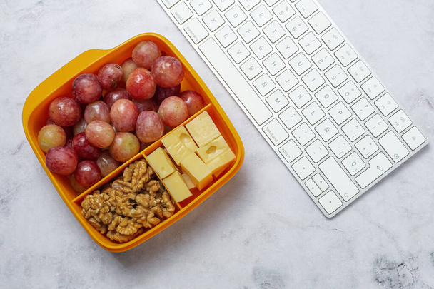 Healthy Food in Plastic containers ready to eat with Cheese, grapes and walnuts on the work table. To take away.walnuts - 写真・画像