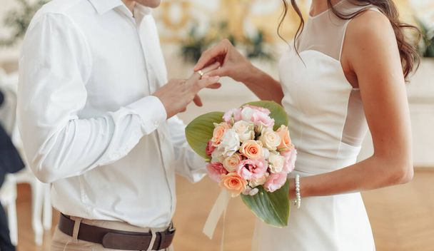 Η νύφη βάζει ένα χρυσό δαχτυλίδι στο δάχτυλο του γαμπρού. γαμήλια τελετή - Φωτογραφία, εικόνα