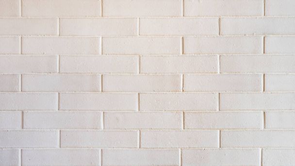 Close-up white brick wall, with staggered tiles and porous texture, home decor or interior design inspiration, stack or stagger of bricks, tiles or stones, pleasing symmetrical pattern with copy space - 写真・画像