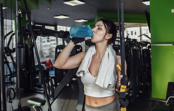 Cansado joven en forma mujer beber agua en el gimnasio - Foto, Imagen