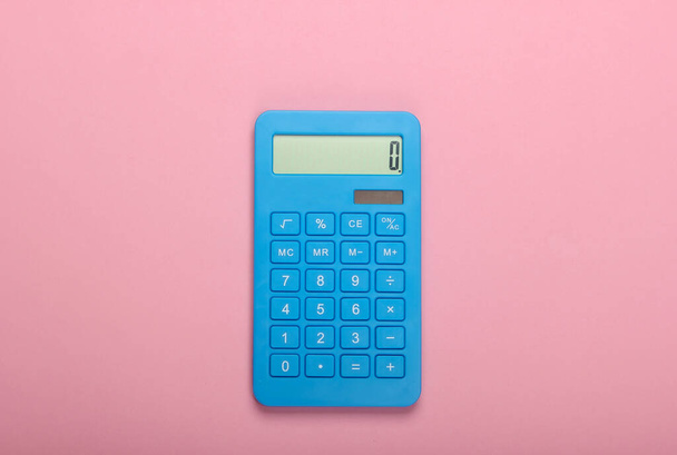 Blue calculator on pink pastel background. Calculation or counting. Minimalism. Top view - 写真・画像