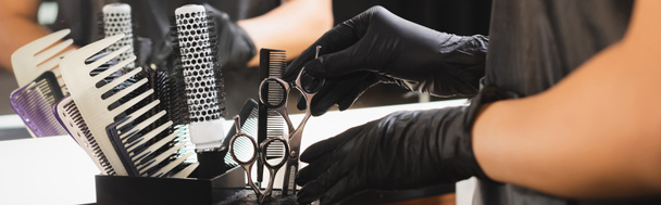 partial view of barber in latex gloves putting scissors in holder, banner - Photo, Image