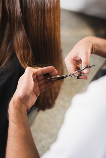 visão cortada do cabelo de corte de cabeleireiro do cliente em primeiro plano borrado - Foto, Imagem