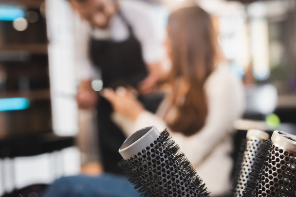 combs near hairdresser and client on blurred background - Fotoğraf, Görsel