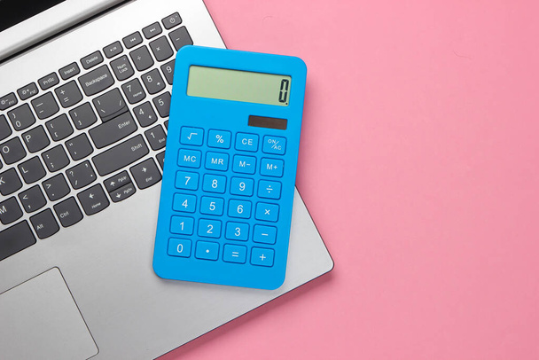 Calculator and laptop on pink pastel background. Top view - Photo, Image