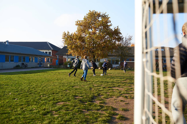 Kids playing soccer at the school playground - Foto, afbeelding