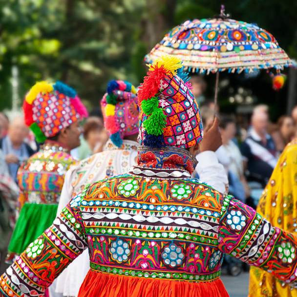 Αρκετοί χορευτές χορεύουν και φορούν την παραδοσιακή λαϊκή φορεσιά από την Ινδία - Φωτογραφία, εικόνα