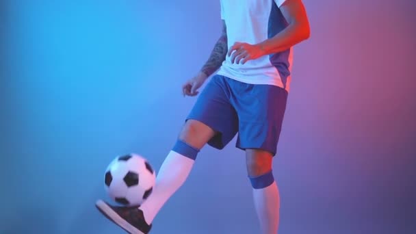 Vista lateral del perfil del jugador de fútbol estilo libre haciendo malabarismos pelota de fútbol con sus piernas, tiro cercano - Metraje, vídeo