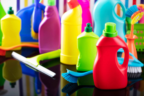 Huis en kantoor schoonmaak thema. Kleurrijke set flessen met klevende vloeistoffen op achtergrond in de vorm van kleurrijke strepen. - Foto, afbeelding
