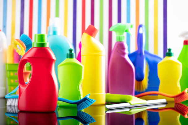 Thema Haus- und Büroreinigung. Buntes Set von Flaschen mit klingenden Flüssigkeiten auf dem Hintergrund in Form von bunten Streifen. - Foto, Bild