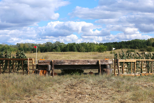 Saltar obstáculo de tronco de caballo en campo traviesa sin jinetes como fondo - Foto, imagen