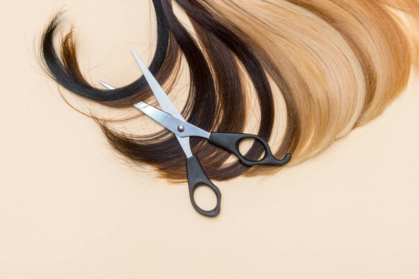 Accessoires de coiffure ciseaux et une mèche de cheveux. Service de coiffure - Photo, image