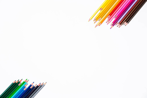 白い背景に2つの側面で分離された色鉛筆のフレームは、テキストのための自由な場所で。子供や大人の創造的な開発と教育のアート文房具とバナー. - 写真・画像