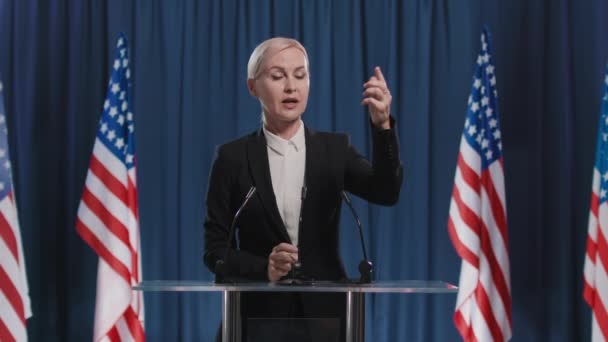 Medium portret shot beelden van emotioneel volwassen vrouwelijke politicus uiten van haar mening over kwestie - Video