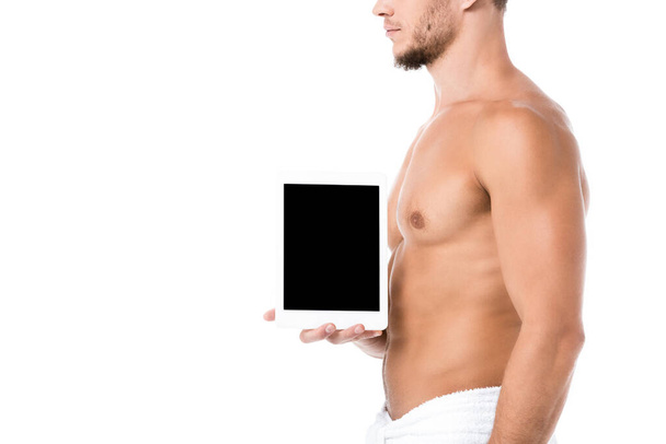 vue recadrée de sexy homme torse nu en serviette présentant tablette numérique isolé sur blanc - Photo, image