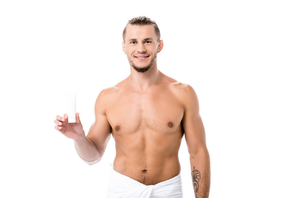 smiling sexy shirtless man in towel with hand cream isolated on white - Φωτογραφία, εικόνα