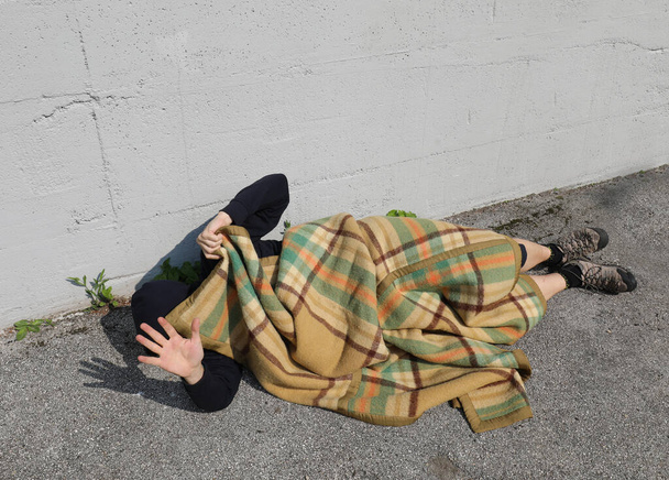 bum under the blanket while being disturbed while sleeping on the street - Photo, Image