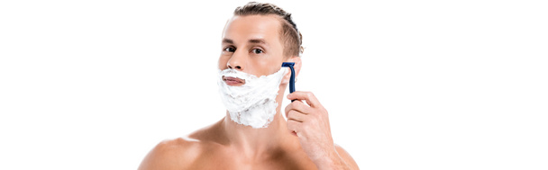 sexy shirtless man with foam on face shaving with razor isolated on white, banner - Fotó, kép