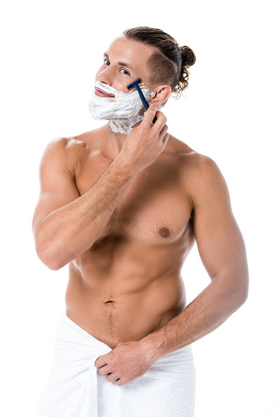 sexy shirtless man with foam on face shaving isolated on white - Fotó, kép