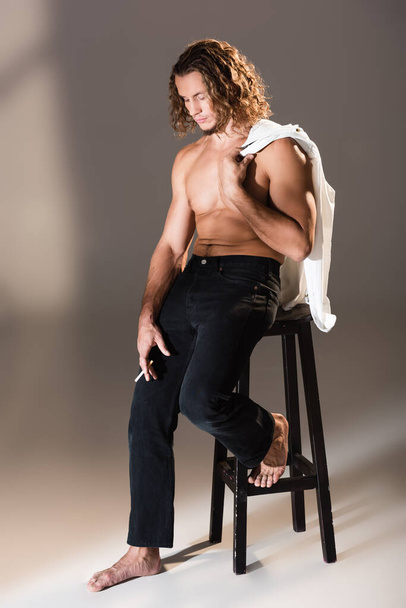sexy shirtless man with long hair smoking on dark background - Foto, imagen