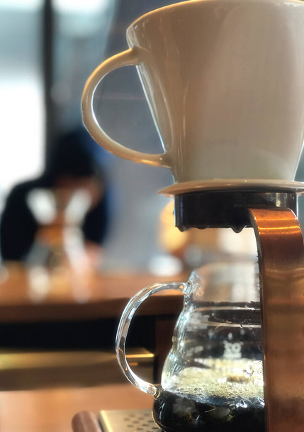 Professional kahvila valmistaa kahvia käyttäen chemex kaada yli kahvinkeitin ja tippua vedenkeitin puinen baari laskuri. tippuva kahvi käsite.  - Valokuva, kuva