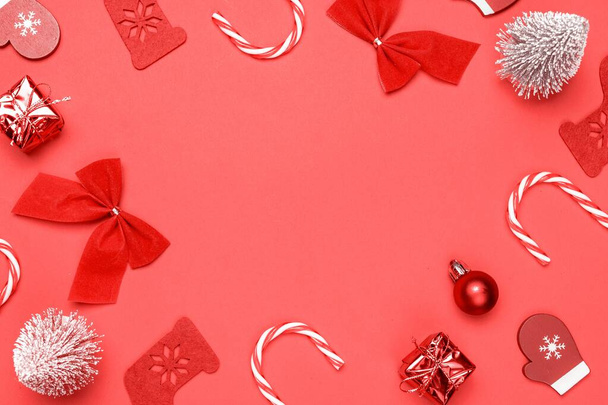 Zimní pozadí červené. Punčochy, dárky, zimní strom, stuha a luk ve tvaru rámu na červeném pozadí pro pozdrav karty. Zimní slavnostní kompozice s kopírovacím prostorem - Fotografie, Obrázek