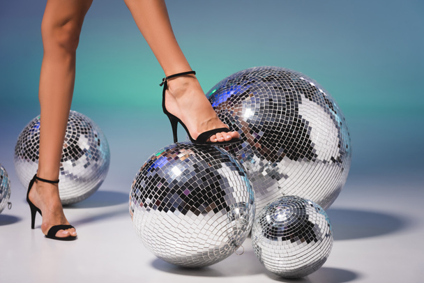 female legs in black shoes on disco ball - Photo, image