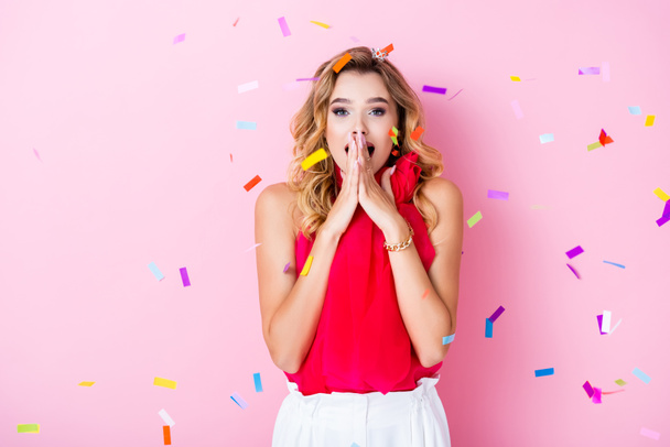 elegant shocked woman in crown under confetti on pink background  - Photo, Image