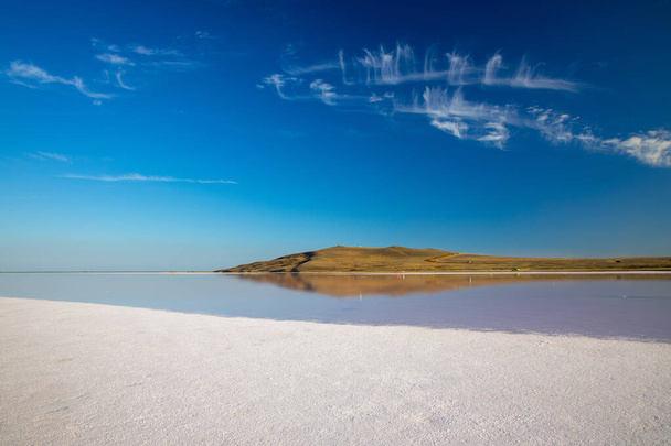 Vaaleanpunainen suolajärvi Sasyk-Sivash, Jevpatoria, Krimillä. Tämän järven vesi on voimakkaasti kyllästetty suolalla ja sillä on vaaleanpunainen väri. Erittäin kaunis maisema vaaleanpunainen järvi ja sininen taivas pilvet. - Valokuva, kuva