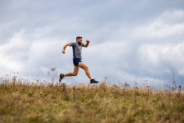 schöner Trail Runner beim Laufen in der Natur - Foto, Bild
