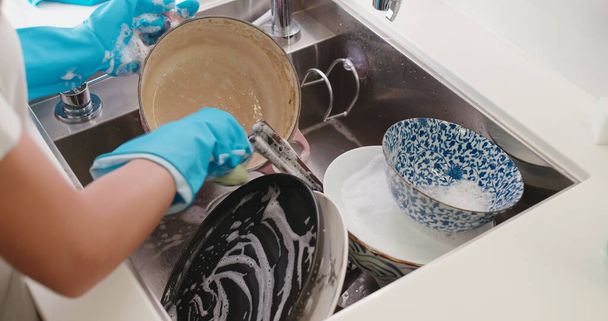 Kobieta zmywa naczynia w kuchni - Zdjęcie, obraz
