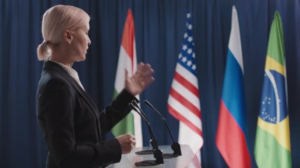 Közepes oldalnézetű felvételek komoly kaukázusi női politikusokról, akik társadalmi kérdésekről beszélnek a nemzetközi fórumon - Felvétel, videó
