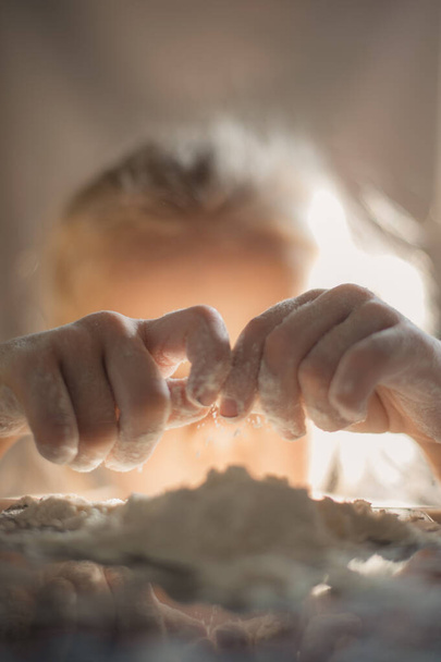 Dziewczyna bawiąca się mąką. Zbliżenie portret dziewczyny bawiącej się mąką - Zdjęcie, obraz