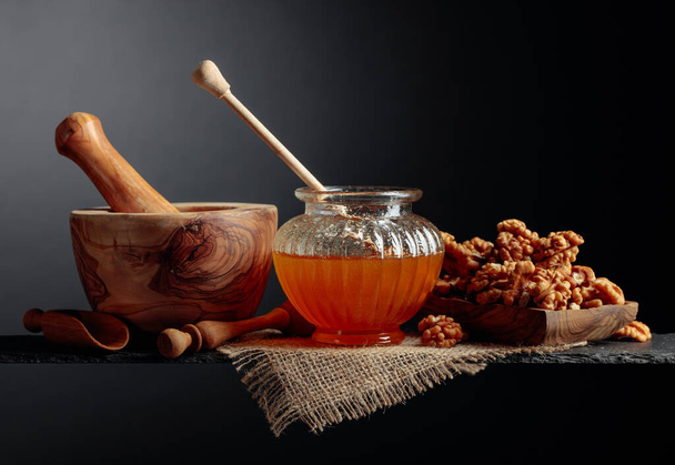 Healthy breakfast background. Honey and walnut on a black background,  copy space. - Photo, Image