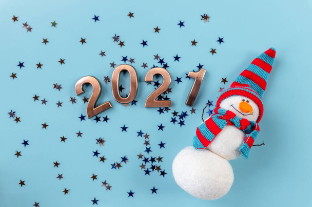 Snowman doll and Christmas decoration on blue background.Happy New Year.New Years Concept Postcard 2021.Golden figures. - Photo, Image