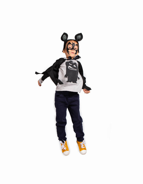 Smiling boy in black bat costume jumping over white background with lots of space. Halloween, holiday and childhood concept. High quality photo - Φωτογραφία, εικόνα