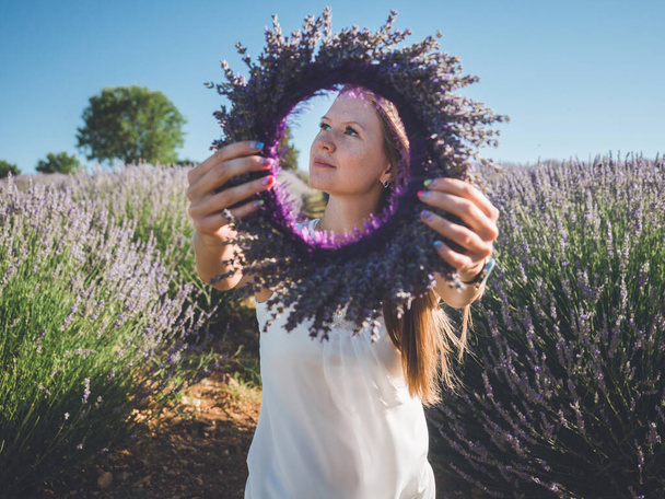 Woman hands with colorful manicure holding lavender wreath - Foto, Bild