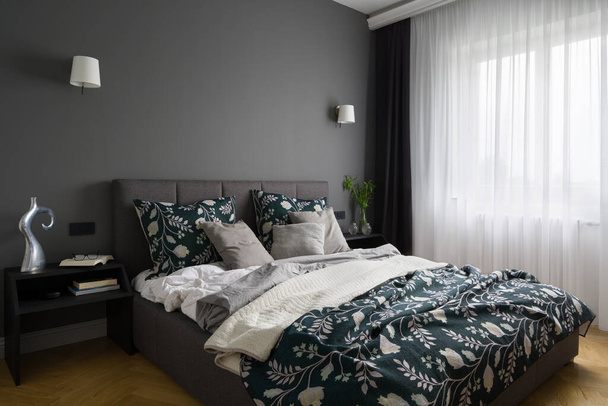 Elegant and stylish bedroom with gray wall, big comfortable bed and big window behind white curtains - Foto, Imagem