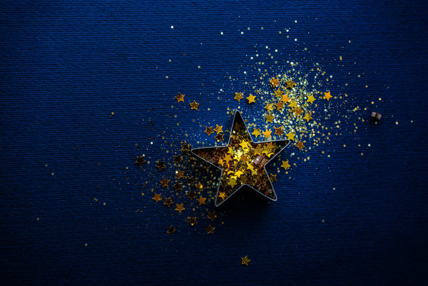 Csillogó csillag alakú dekoráció mély kék háttér, mint egy karácsonyi kártya koncepció - Fotó, kép