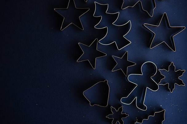 Vánoční byt ležel s řezačkami cookies na hlubokém modrém pozadí - Fotografie, Obrázek