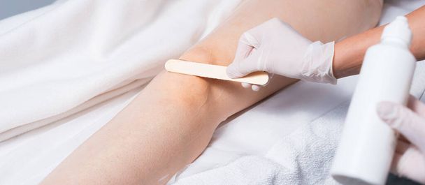 Photo rapprochée de la jambe de la femme préparant avec de la cire avant l'épilation au laser - Photo, image