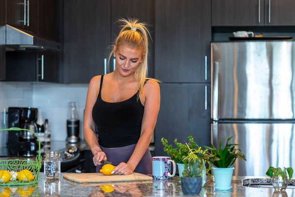 Un magnifique mannequin blonde prépare un repas avant de se rendre au travail - Photo, image