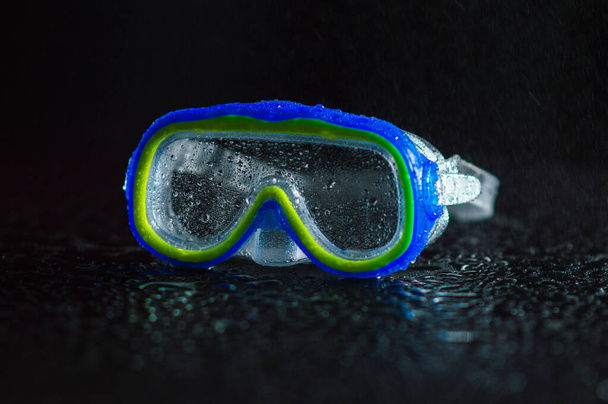 gafas para nadar mojado en gotas de agua azul transparente - Foto, imagen