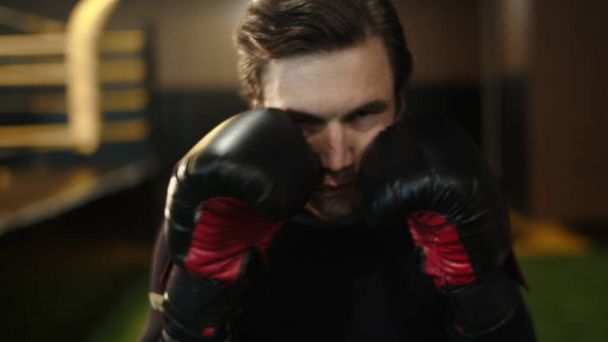 Eager male athlete making blows in sport club. Boxer training kicks at gym - Photo, Image
