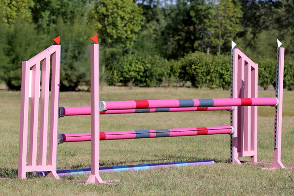 Image colorée de mâts de saut d'obstacles dans une arène de saut d'obstacles en plein air. Obstacles poteaux barrières pour sauter des chevaux comme toile de fond - Photo, image