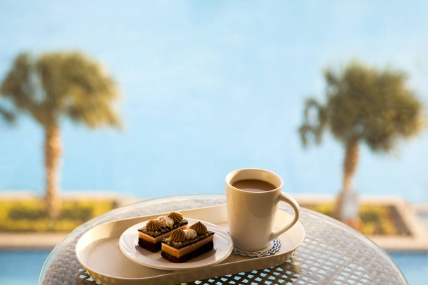 Odpoledne Káva set s teplým americano s mlékem, čokoládové brownie v bazénu v hotelovém resortu pozadí. - Fotografie, Obrázek