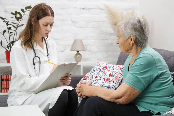 Senior patient having consultation with doctor in the home care or geriatric center - Photo, Image