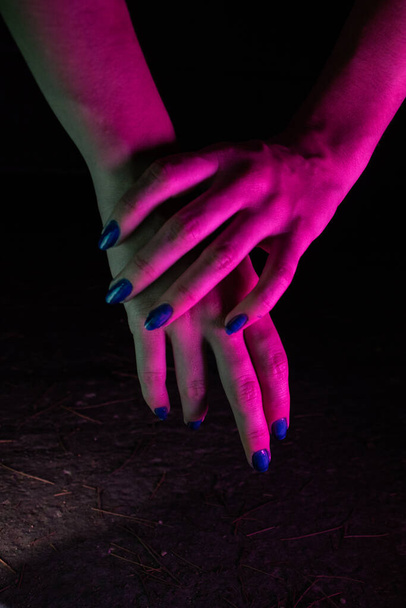 Manos femeninas con una luz de neón rosa - Foto, Imagen