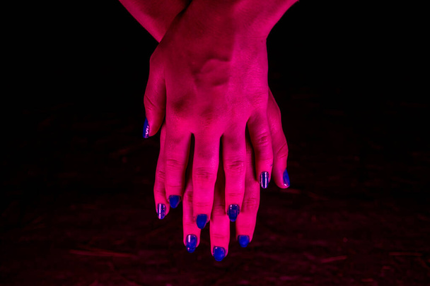 Pembe neon ışıklı kadınsı eller. - Fotoğraf, Görsel